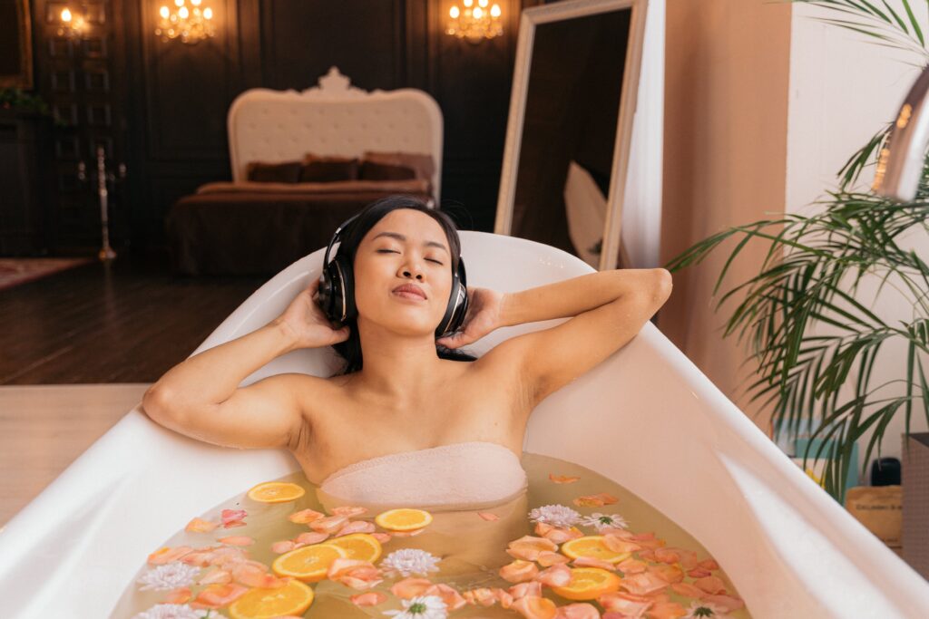Young woman listening to music in a bath tub