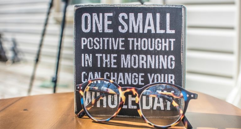 Photo of a Sign and Eyeglasses on Table
