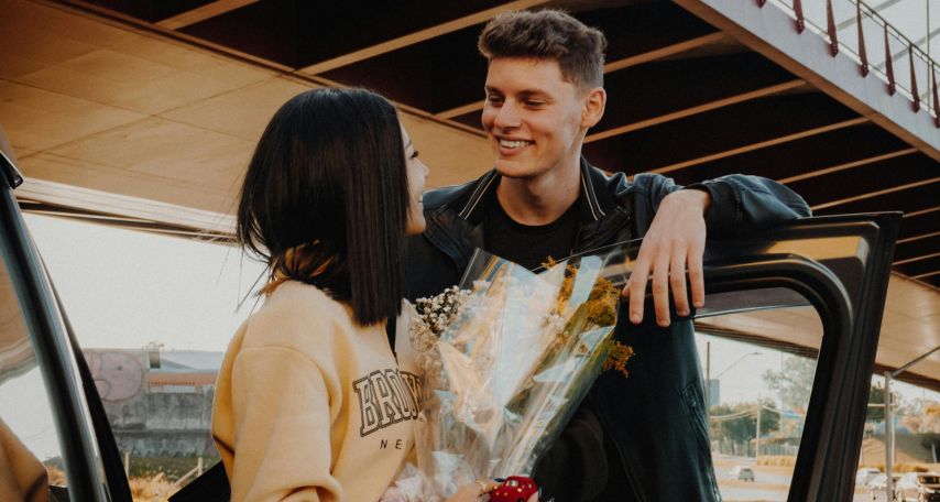 Woman Holding Flowers and Looking at Her Boyfriend
