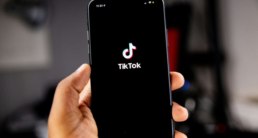 Person holding an iPhone running TikTok