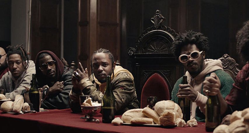 Kendrick Lamar surrounded by TDE members like Ret One, Mackwop, Jay Rock, Blue, MixedByAli, and Sounwave